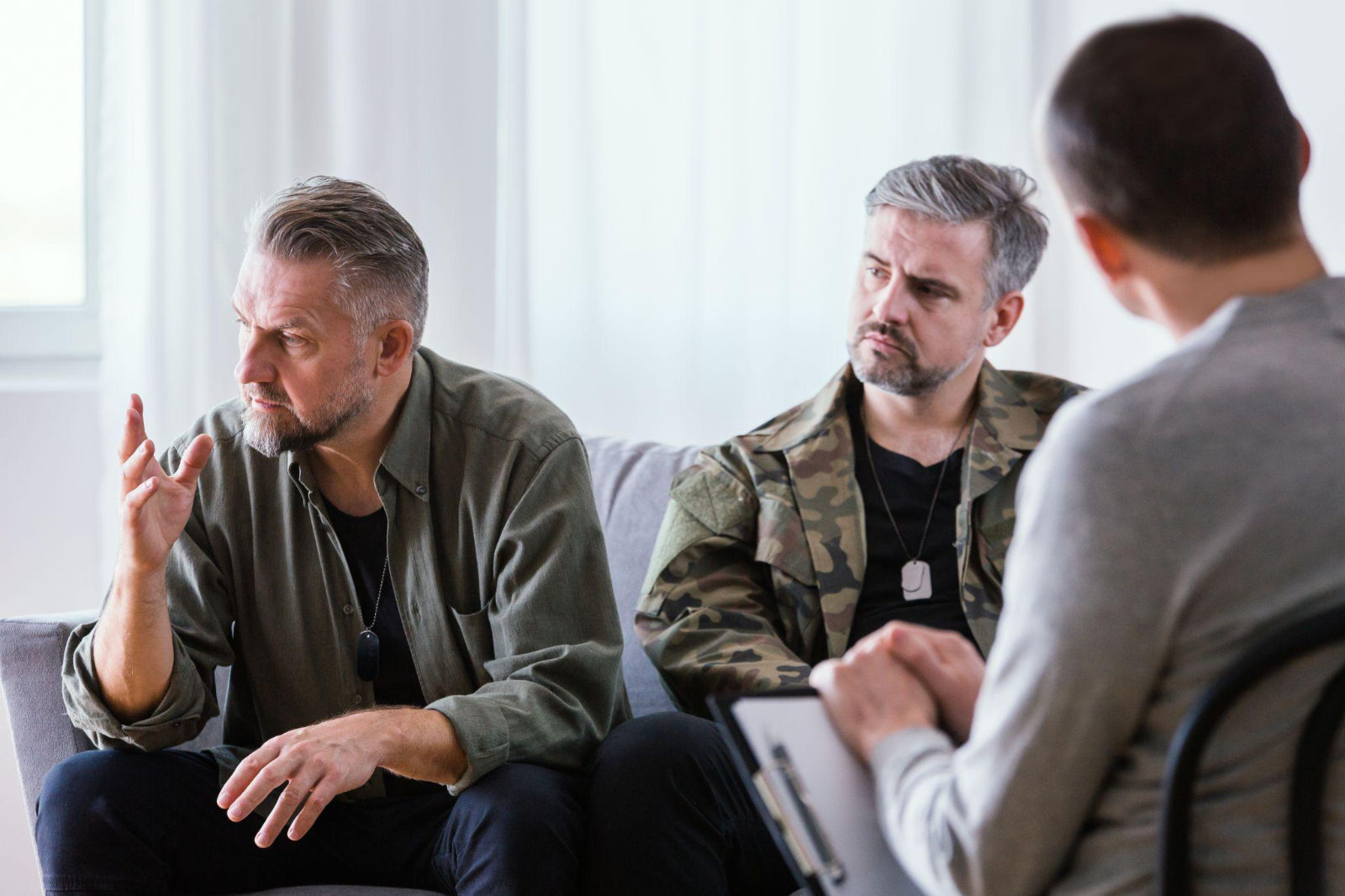 Addiction counselor leading a small support group meeting with men discussing recovery