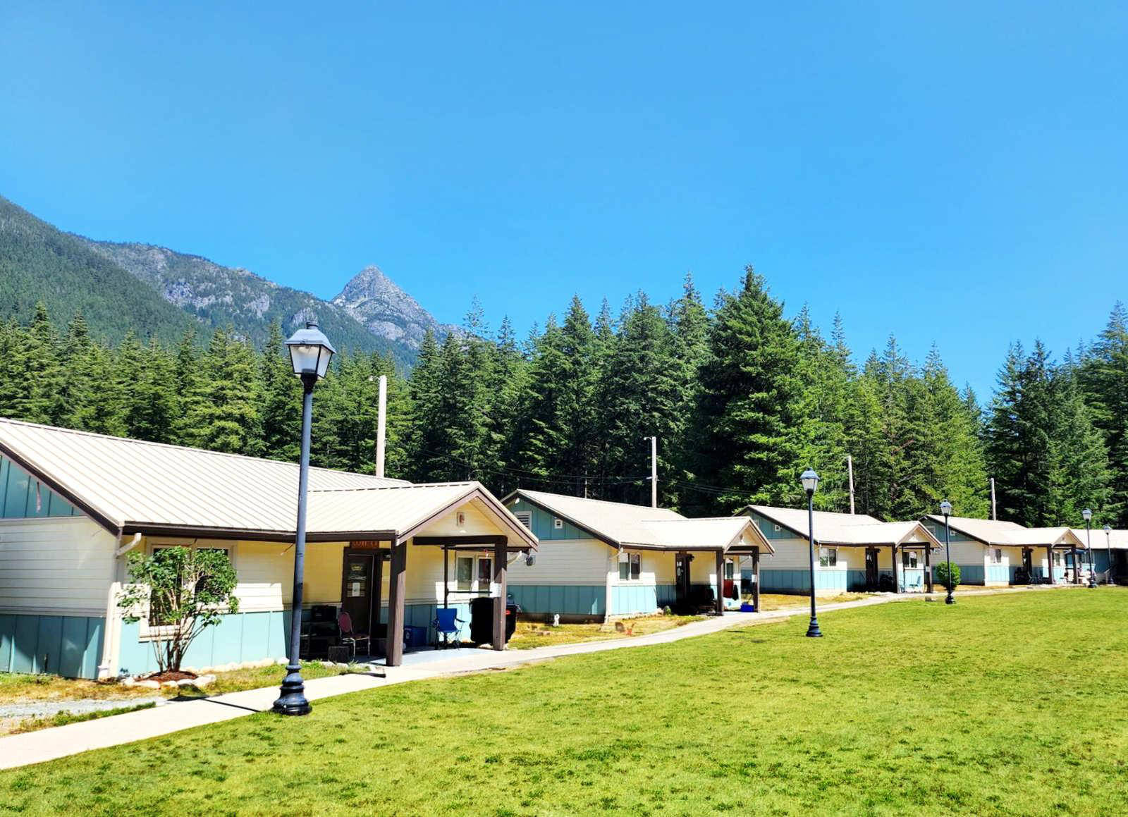 Exterior view of the Joshua House residential addiction recovery campus surrounded by mountains and trees in BC