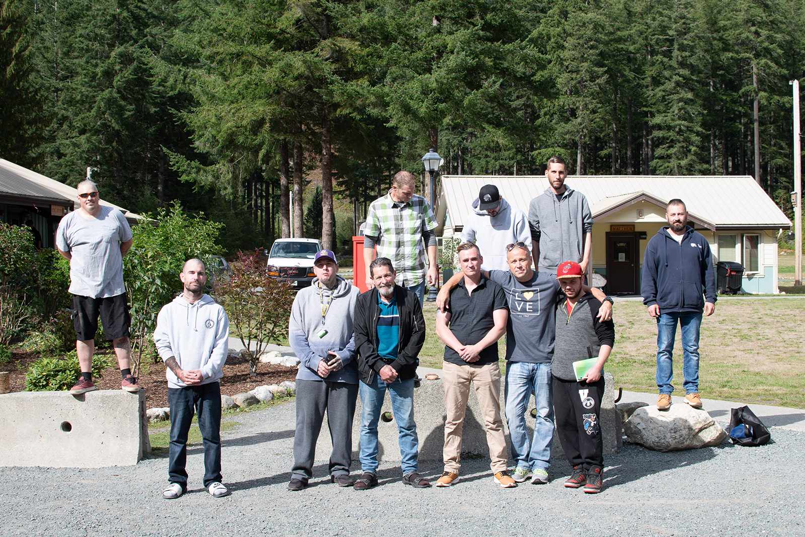 A group of men standing together outdoors in a supportive recovery community at Joshua House.